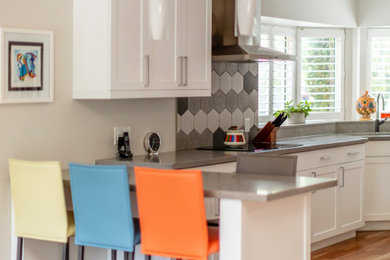 Inspiration for a mid-sized transitional u-shaped medium tone wood floor and brown floor open concept kitchen remodel in Toronto with an undermount sink, shaker cabinets, white cabinets, quartz countertops, multicolored backsplash, porcelain backsplash, stainless steel appliances, a peninsula and gray countertops