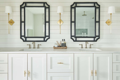 Corner shower - large coastal master porcelain tile, white floor, double-sink and shiplap wall corner shower idea in Charlotte with shaker cabinets, white cabinets, white walls, an undermount sink, quartz countertops, a hinged shower door, white countertops, a niche and a built-in vanity
