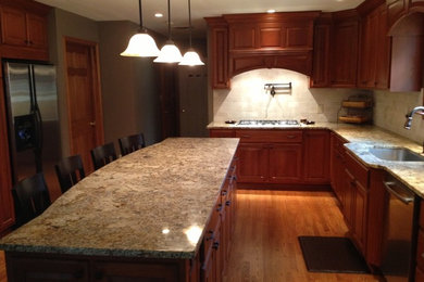Inspiration for a mid-sized timeless kitchen remodel in New York with an undermount sink, granite countertops, beige backsplash, stainless steel appliances and an island
