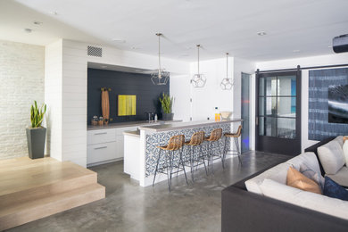 Design ideas for a large beach style single-wall seated home bar in Orange County with concrete floors, grey floor, flat-panel cabinets, white cabinets, blue splashback, timber splashback and grey benchtop.