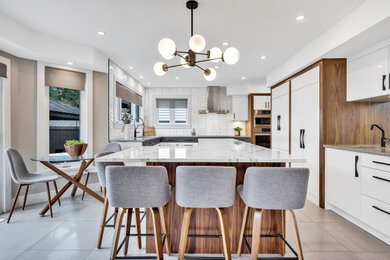 Photo of a contemporary u-shaped eat-in kitchen in Ottawa with white cabinets, white splashback, an undermount sink, flat-panel cabinets, panelled appliances, with island, grey floor and grey benchtop.