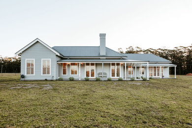 Country one-storey grey house exterior in Other.