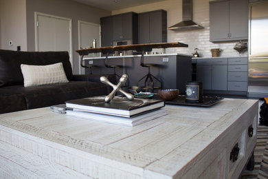 Example of a large urban open concept dark wood floor living room design in Denver with gray walls, no fireplace and a wall-mounted tv