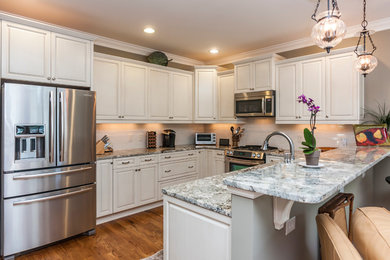 Inspiration for a transitional light wood floor kitchen remodel in Raleigh with granite countertops, white backsplash, subway tile backsplash and stainless steel appliances