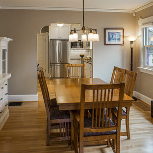 Cette photo montre une salle à manger ouverte sur la cuisine craftsman de taille moyenne avec un mur beige et un sol en bois clair.