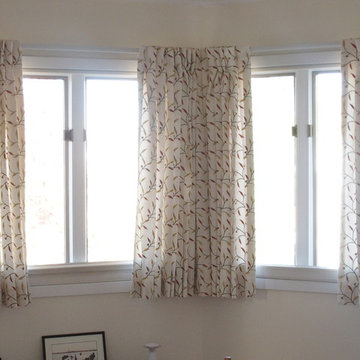 Bedroom draperies in offwhite linen blend with embroidered leaves.