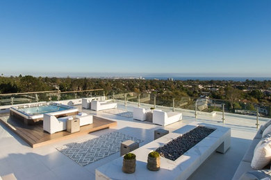 Example of a huge trendy rooftop rooftop deck design in Los Angeles with a fire pit and no cover