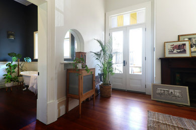 Foto de dormitorio tradicional grande con paredes blancas, suelo de madera oscura y panelado