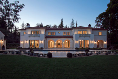 Example of a huge tuscan white two-story stucco exterior home design in San Francisco with a hip roof