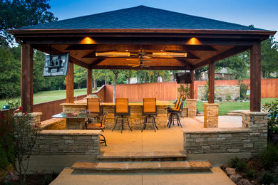 Large arts and crafts backyard patio in Oklahoma City with an outdoor kitchen, concrete slab and a gazebo/cabana.
