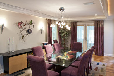 Enclosed dining room - large contemporary medium tone wood floor enclosed dining room idea in New York with gray walls