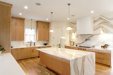 Example of a minimalist light wood floor kitchen design in Other with an undermount sink, flat-panel cabinets, quartz countertops, metallic backsplash, quartz backsplash, paneled appliances, an island and white countertops