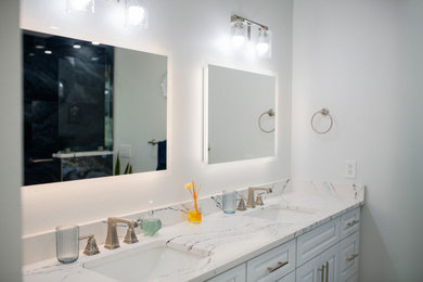 Example of a minimalist master double-sink bathroom design in Tampa with white cabinets and a built-in vanity