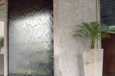 Cortina de agua sobre mármol, en acceso a un edificio de oficinas
