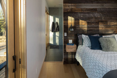 Diseño de dormitorio principal escandinavo de tamaño medio con paredes marrones, suelo de madera clara y suelo marrón