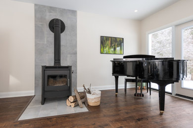 Inspiration for a mid-sized modern vinyl floor and brown floor family room remodel in Ottawa with a music area, a wood stove, a tile fireplace and no tv