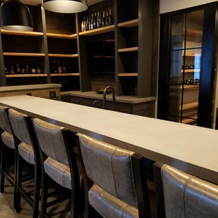 This is an example of a large traditional walk-out basement in Kansas City with grey walls, ceramic flooring, a standard fireplace, a concrete fireplace surround and grey floors.