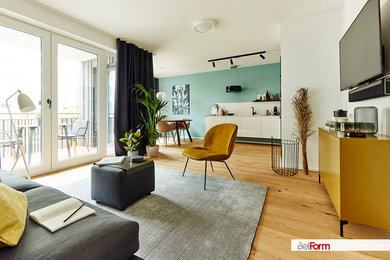 Offenes Modernes Wohnzimmer mit weißer Wandfarbe, braunem Holzboden und TV-Wand in München