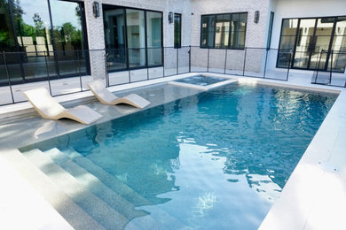Example of a large minimalist backyard rectangular lap pool design in Orlando