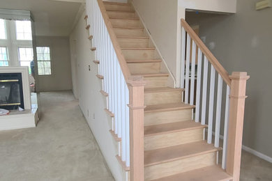 Example of a large beach style wooden straight wood railing staircase design in New York with wooden risers