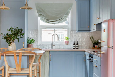 Design ideas for a small scandi l-shaped kitchen in Belfast with shaker cabinets, laminate countertops, ceramic splashback, medium hardwood flooring, a breakfast bar, a built-in sink, blue cabinets, white splashback, coloured appliances, brown floors and beige worktops.