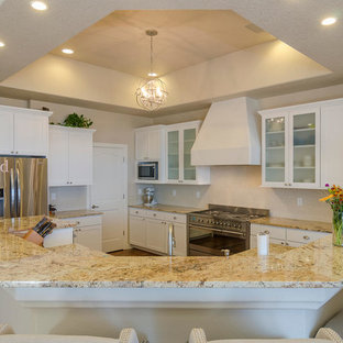 Mid-sized southwestern kitchen pantry ideas - Inspiration for a mid-sized southwestern l-shaped dark wood floor kitchen pantry remodel in Albuquerque with an undermount sink, shaker cabinets, white cabinets, granite countertops, beige backsplash, glass sheet backsplash, stainless steel appliances and an island