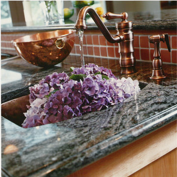 Kitchen with copper range hood, sink & faucets.