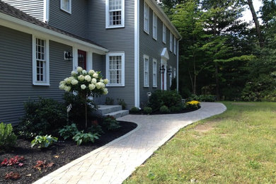 This is an example of a mid-sized traditional partial sun front yard concrete paver garden path in Boston.