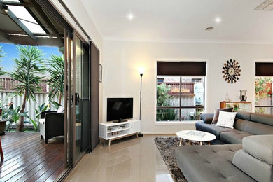Mid-sized contemporary open concept living room in Melbourne with white walls, porcelain floors, a freestanding tv and beige floor.