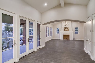 Inspiration for a mid-sized transitional formal and open concept porcelain tile and gray floor living room remodel in San Diego with white walls, a standard fireplace, a plaster fireplace and no tv