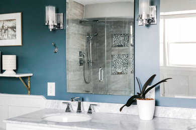 Inspiration for a mid-sized transitional master beige tile and ceramic tile ceramic tile and brown floor corner shower remodel in Minneapolis with shaker cabinets, white cabinets, a two-piece toilet, blue walls, an integrated sink, marble countertops and a hinged shower door