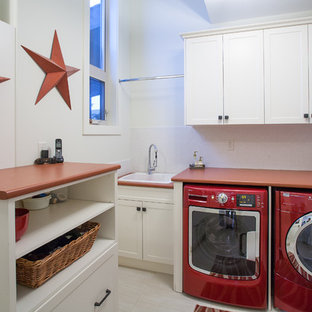 バンクーバーのトラディショナルスタイルのおしゃれなランドリールーム (ドロップインシンク、左右配置の洗濯機・乾燥機、赤いキッチンカウンター) の写真
