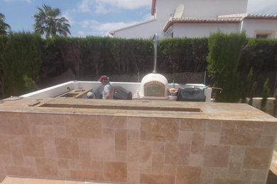 Foto de patio mediterráneo pequeño sin cubierta en patio con cocina exterior y adoquines de piedra natural