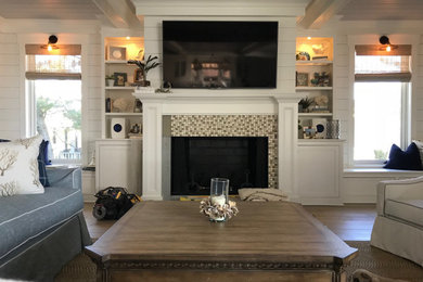 Mid-sized beach style open concept light wood floor and brown floor living room photo in Other with white walls, a standard fireplace, a tile fireplace and a wall-mounted tv