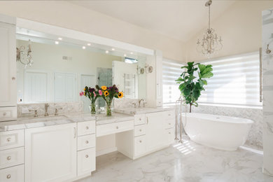 Inspiration for a traditional bathroom in Los Angeles with recessed-panel cabinets, white cabinets, a freestanding tub, gray tile, beige walls, an undermount sink, white floor, grey benchtops, a double vanity and vaulted.
