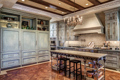 Large tuscan u-shaped medium tone wood floor and brown floor kitchen photo in Other with beaded inset cabinets, gray cabinets, gray backsplash, paneled appliances and an island