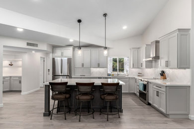 Mid-sized transitional porcelain tile and gray floor eat-in kitchen photo in Phoenix with an undermount sink, shaker cabinets, gray cabinets, quartz countertops, white backsplash, subway tile backsplash, stainless steel appliances, an island and white countertops