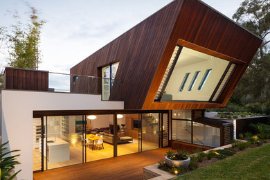 Photo of a contemporary two-storey exterior in Sydney with wood siding.