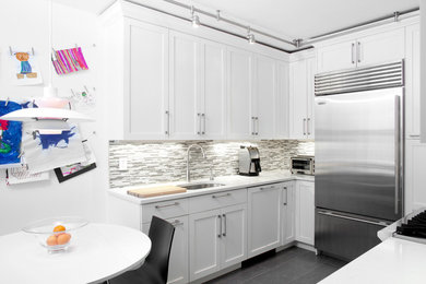 Trendy u-shaped eat-in kitchen photo in New York with an undermount sink, shaker cabinets, white cabinets, gray backsplash, matchstick tile backsplash and stainless steel appliances