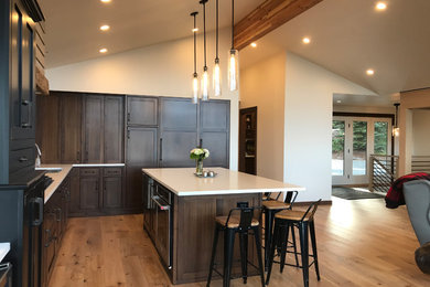 Open concept kitchen - large traditional l-shaped light wood floor open concept kitchen idea in Seattle with an undermount sink, beaded inset cabinets, dark wood cabinets, quartz countertops, white backsplash, ceramic backsplash, paneled appliances, an island and white countertops