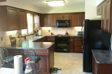 Inspiration for a mid-sized timeless u-shaped eat-in kitchen remodel in Other with a double-bowl sink, medium tone wood cabinets, laminate countertops, ceramic backsplash and black appliances