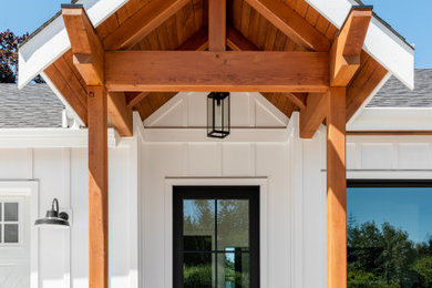 Large cottage white one-story wood and board and batten house exterior idea in Other with a black roof