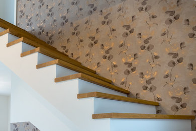 Ejemplo de escalera en L actual de tamaño medio con escalones de madera y contrahuellas de madera