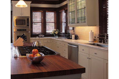 Inspiration for a timeless light wood floor kitchen remodel in Seattle with an undermount sink, flat-panel cabinets, white cabinets, white backsplash, ceramic backsplash, stainless steel appliances and an island