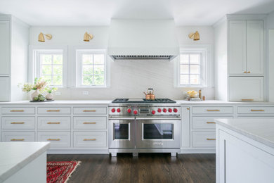 Inspiration for a mid-sized transitional medium tone wood floor and brown floor eat-in kitchen remodel in Austin with an undermount sink, recessed-panel cabinets, white cabinets, quartzite countertops, multicolored backsplash, stone slab backsplash, white appliances, an island and gray countertops