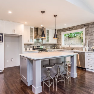 Modern inredning av ett stort vit vitt kök, med en nedsänkt diskho, vita skåp och rostfria vitvaror