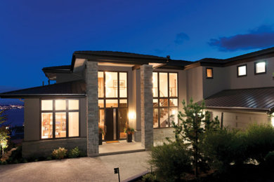 Large trendy brown two-story mixed siding house exterior photo with a hip roof and a shingle roof
