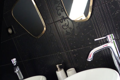 Inspiration pour une salle de bain minimaliste avec un placard à porte affleurante, des portes de placard noires, un carrelage noir, des carreaux de céramique, un mur noir, une grande vasque, un plan de toilette en surface solide et un plan de toilette noir.