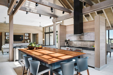 Inspiration for a cottage l-shaped gray floor kitchen remodel in Austin with shaker cabinets, white cabinets, gray backsplash, stainless steel appliances, an island and black countertops