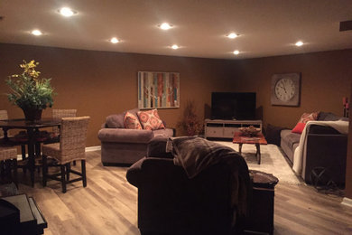 Basement - large contemporary underground laminate floor and beige floor basement idea with brown walls